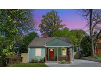 Charming renovated bungalow with a red front door, green siding, and inviting front porch at 1518 Langston Sw Ave, Atlanta, GA 30310