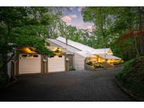 Unique modern home exterior with a striking white roof, two-car garage, and lush landscaping at 1121 Dawn View Nw Ln, Atlanta, GA 30327