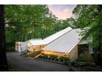 Stunning home exterior featuring modern architecture, lush greenery, and a private driveway at 1121 Dawn View Nw Ln, Atlanta, GA 30327