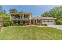 Charming brick home with a well-manicured lawn and an inviting second story balcony at 1924 Windburn Ct, Snellville, GA 30078