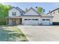 Charming two-story home featuring a three-car garage and stone accents, complemented by a well-manicured lawn at 110 Legion Dr, Buford, GA 30518