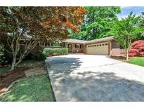 Charming brick ranch with well-maintained landscaping and a wide driveway leading to the two-car garage at 1280 Berkeley Rd, Avondale Estates, GA 30002