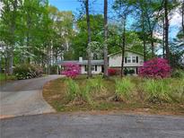 Charming home featuring mature trees, colorful shrubbery, and an inviting front drive at 4561 N Woodlake Se Ln, Conyers, GA 30013