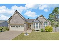 Charming single-Gathering home features a well-maintained lawn, attached two-car garage, and classic brick facade at 2800 Araglin Dr, Dacula, GA 30019