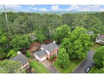 Stunning aerial view of brick home nestled in a lush, green neighborhood at 4213 Schooner Ne Ct, Roswell, GA 30075