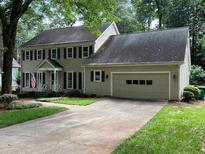 Traditional two-story home with beige siding, black shutters, and attached two car garage at 7260 Dunhill Ter, Atlanta, GA 30328