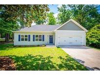 Charming one-story home with a two-car garage, well-manicured lawn, and blue shutters at 4694 E Glen Ridge E Cir, Winston, GA 30187
