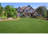 Charming two-story brick home featuring a lush green lawn and beautifully landscaped front yard at 3704 Wilkins Cir, Powder Springs, GA 30127