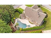 Aerial view of a backyard pool with a patio and lush landscaping surrounding the area at 134 Lakestone Pkwy, Woodstock, GA 30188