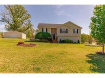 Charming home with a manicured lawn and a detached garage on a sunny day at 15 Cobblestone Ct, Douglasville, GA 30134
