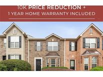 Charming townhome showcasing a brick facade, complemented by meticulously manicured landscaping and symmetrical shuttered windows at 4413 Pinscher St, Union City, GA 30291