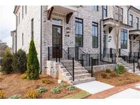 Attractive townhome showcasing a brick facade, black accents, and manicured landscaping at 560 Fisher Dr # 48, Alpharetta, GA 30009