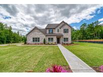 Beautiful, two-story home featuring a brick facade, manicured lawn, and inviting walkway at 700 Relic Rdg, Hampton, GA 30228