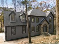 Gray home with a stone entryway and dormer windows, offering a charming and unique exterior appeal at 270 Boulder Dr, Roswell, GA 30075