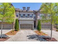 Charming townhome with a two-car garage, manicured landscaping, and classic architectural details at 1005 Milhaven Dr, Roswell, GA 30076