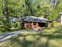 Cozy brick home surrounded by mature trees and greenery along a driveway at 2216 Polar Rock Sw Ave, Atlanta, GA 30315
