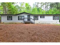 Charming single story home with light siding, dark shutters and trim, and inviting front porch at 350 White Birch Dr, Covington, GA 30016