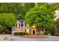 Charming brick home with lush landscaping, mature trees, and a cozy front porch at 4350 Oakdale Vinings Se Cir, Smyrna, GA 30080