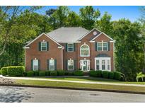 Traditional red brick home with green shutters and meticulously maintained landscaping at 1517 Granby Ln, Locust Grove, GA 30248