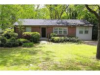 Charming one story brick home with lush landscaping, mature trees, and a well-manicured lawn at 3207 Canary Ct, Decatur, GA 30032