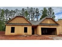 Unfinished exterior view of a single-story home with a two-car garage and an unfinished yard at 486 Charleston Pl, Villa Rica, GA 30180