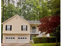 Charming home with two-car garage, inviting front porch, and beautifully landscaped front yard at 1043 Foxhollow Trl, Canton, GA 30115