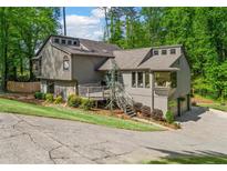 Stunning home features a multi-level deck, mature trees, and lush landscaping creating a private outdoor retreat at 3603 Allpoint Dr, Marietta, GA 30062