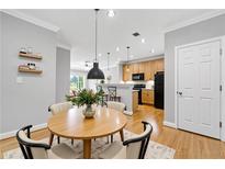 Bright dining area with modern lighting fixtures, light wood flooring, and views to the kitchen at 4201 Stratford Commons, Decatur, GA 30033