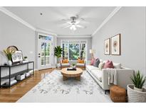 Bright living room featuring a ceiling fan, white sofa, and natural light from a nearby window and door to the exterior at 4201 Stratford Commons, Decatur, GA 30033