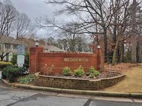Welcoming neighborhood sign for Wedgewood community featuring manicured landscaping at 6401 Wedgeview Ct # 6401, Tucker, GA 30084