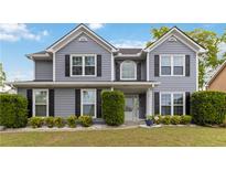 Charming two-story home with gray siding, black shutters, manicured lawn, and a welcoming front porch at 900 Hillary Ln, Lawrenceville, GA 30043