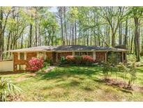 Charming brick home surrounded by lush greenery and flowering shrubs at 2680 Irene Dr, Marietta, GA 30066