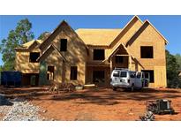 An in-progress build of a large, two-story home with wood framing and a prominent gable roof design at 409 Thunder Rd, Buford, GA 30518