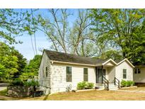 Charming home exterior with mature trees, lush greenery, and inviting curb appeal at 3143 Church St, East Point, GA 30344