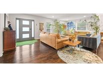 Bright living room with hardwood floors, modern decor, and a stylish front door at 3143 Church St, East Point, GA 30344