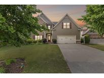 Charming two-story home with well-manicured lawn, two-car garage, and attractive architectural details at 8275 Majors Ridge Way, Cumming, GA 30041