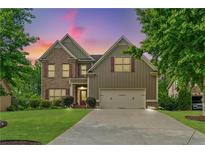 Two-story home featuring a brick and siding facade, well-manicured lawn, and two-car garage at 8275 Majors Ridge Way, Cumming, GA 30041