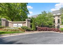 Elegant entrance to Le Chateau, featuring lush landscaping and a stately sign at 2865 Lenox Ne Rd # 504, Atlanta, GA 30324