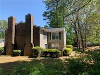 Charming two-story condo featuring a brick chimney, lush landscaping and serene surroundings at 574 Trillum Sw Ct, Marietta, GA 30008