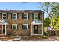 Charming brick townhome featuring classic shutters and a well-maintained front yard with stone and mulch at 6700 Roswell Rd # 19F, Atlanta, GA 30328