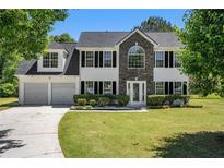 Charming two-story home with a well-manicured lawn, two-car garage, and beautiful landscaping at 1076 Field View Dr, Mcdonough, GA 30253