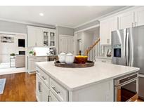 Bright kitchen with white cabinets, stainless steel appliances, and a large center island at 1315 Woodland Trce, Cumming, GA 30041