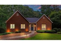 Charming brick home with manicured lawn, walkway to front door, and classic architectural details at 521 Smithstone Se Rd, Marietta, GA 30067
