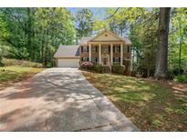 Charming two-story brick home with a columned front porch and a well-manicured front yard at 4128 Mayflower Sw Ct, Lilburn, GA 30047