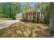 Charming two-story home featuring a traditional facade with a well-manicured front yard at 4128 Mayflower Sw Ct, Lilburn, GA 30047