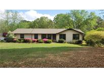 Charming ranch home with well-maintained lawn and colorful azalea bushes along the front at 4909 Woodhurst Way, Stone Mountain, GA 30088