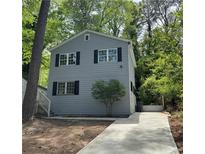 Charming two-story home with gray siding, black shutters, and a newly poured concrete driveway at 948 Reed Ave, Atlanta, GA 30344