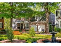 Elegant brick home featuring a well-manicured lawn with bench and beautiful water fountain at 1144 Bellewood Sq, Dunwoody, GA 30338