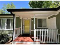 Inviting front porch with a bright yellow door and white railings, offering a welcoming entrance to the home at 921 Hemingway Rd, Stone Mountain, GA 30088