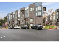 Modern townhome exterior featuring brick facade, balconies, and well-maintained landscaping against a backdrop of blue skies at 1050 Stacks Ave # 1507, Atlanta, GA 30315